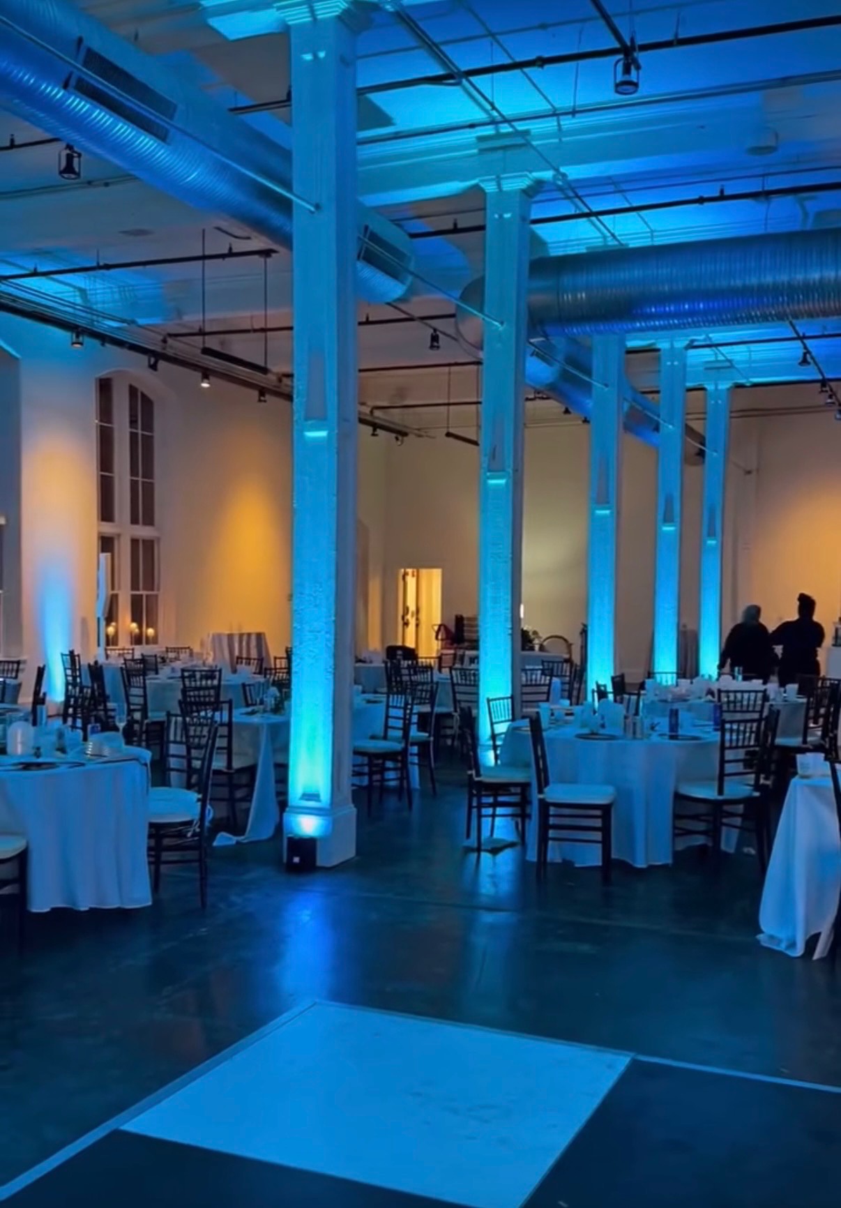 Blue Venue Uplighting illuminating columns around a wedding Reception